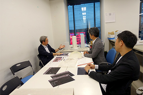 対談風景。新宿住友ビル3階現場事務所の窓の外には、三角広場の屋根梁と大型ビジョンが見える。